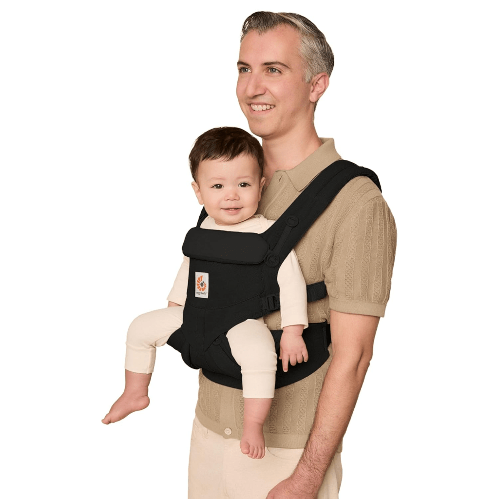 Adjustable baby carrier worn by a dad holding a newborn